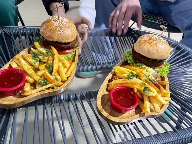 שני מגשי עץ עם לחמניות שומשום במילוי בשר ותפוחי אדמה מטוגנים