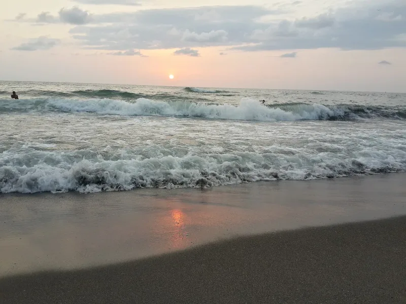 גלים נשברים על החוף בשקיעה