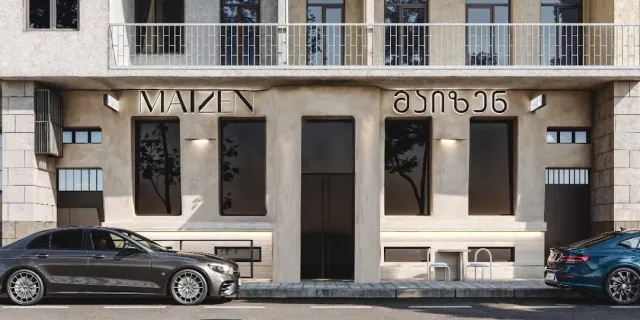 חזית אבן בהירה ומינימלית עם אותיות מתכת על הקיר ומכוניות חונות לפניה