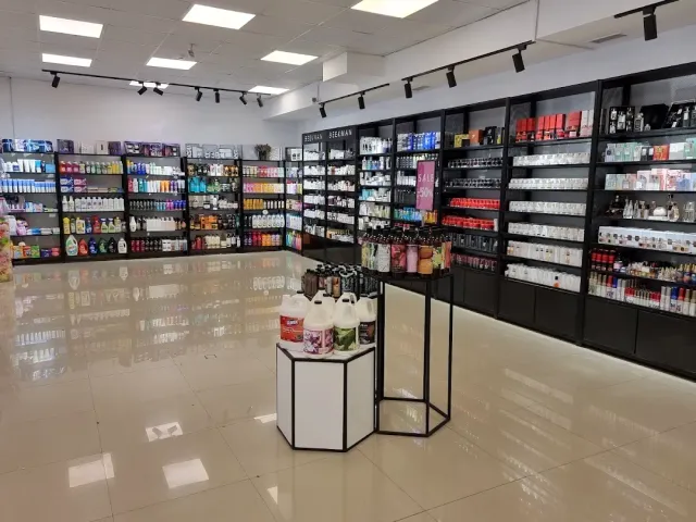 חנות עם מדפים שחורים עמוסי מוצרי טיפוח, רצפה מבריקה ומעמד תצוגה במרכז